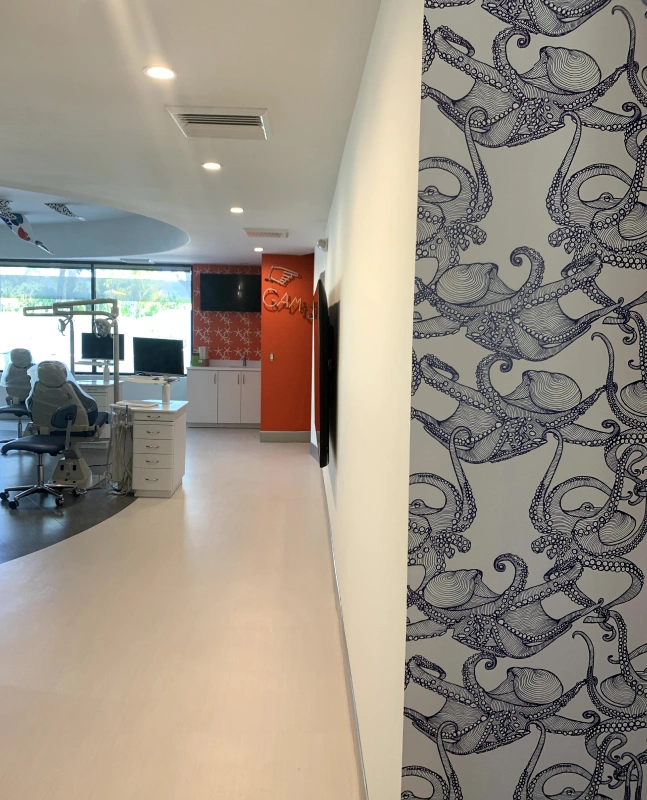 Modern orthodontic office interior with decorative wallpaper and sleek reception area.